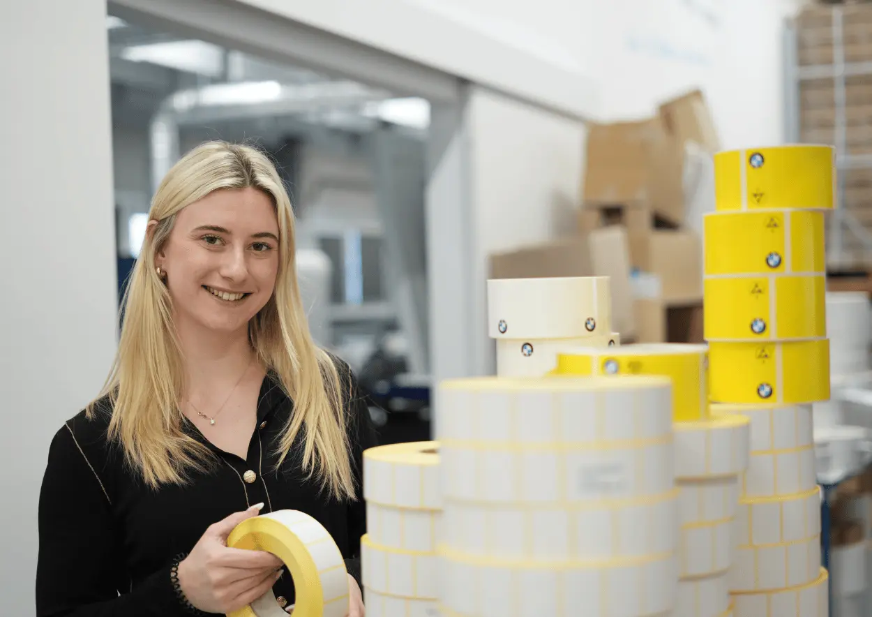 Etikettenstapel Eine Mitarbeiterin steht neben einem großen Etikettenstapel.